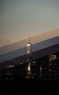 Illuminated buildings against sky at sunset