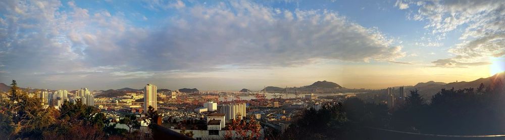 Panoramic view of illuminated city against sky during sunset