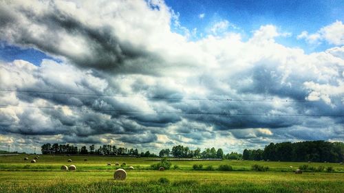 Scenic view of field against cloudy sky