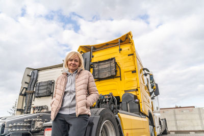 Low angle view of woman standing by truck