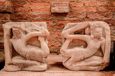 Close-up of old statue against wall