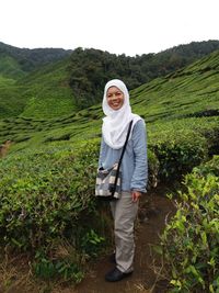 Portrait of woman standing at tea plantation