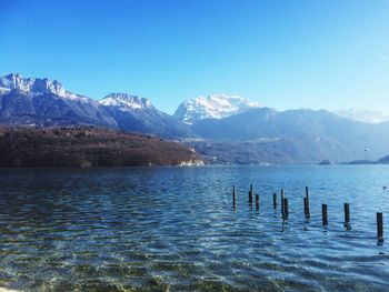 Scenic view of lake and mountains against clear blue sky