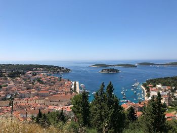 High angle view of townscape by sea against clear sky