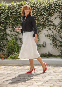 Full length of woman standing against wall