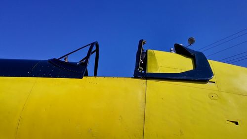 Low angle view of vehicle against clear blue sky
