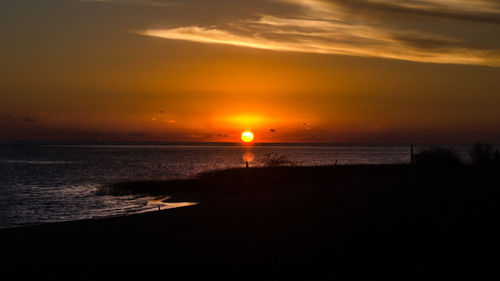 Scenic view of sea against orange sky