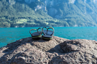 Flip-flops on rock by sea