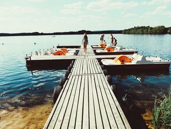 People on lake against sky