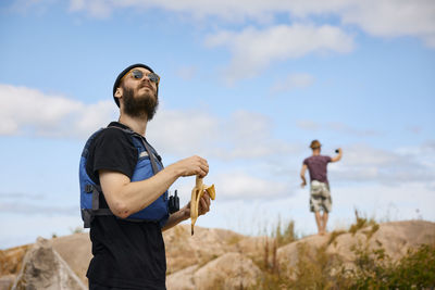 Man standing on coast and peeling banana