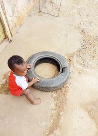 Young boy playing with tyre.