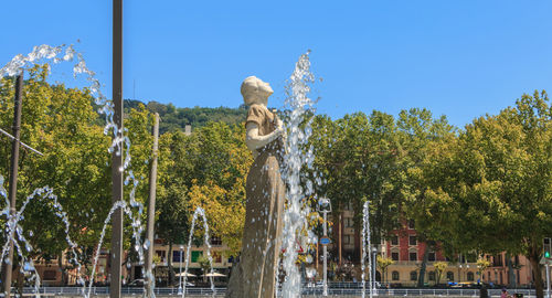 Statue by trees against clear sky