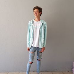 Portrait of smiling young man standing against wall