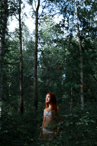 Woman wearing bikini while standing in forest