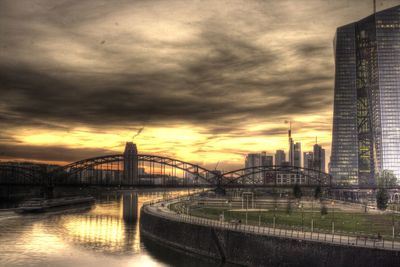 Bridge over river against cloudy sky