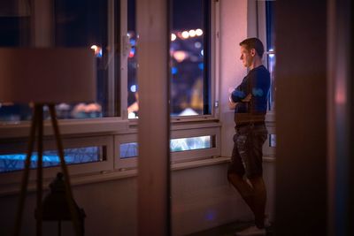 Man looking through window at home