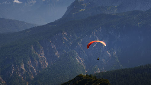 Person paragliding over mountain