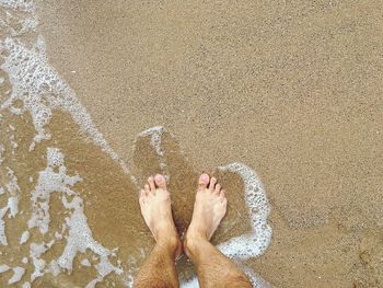 Low section of person on wet sand