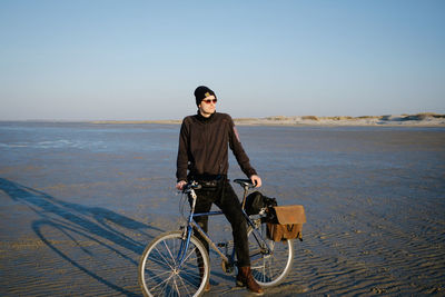 Portrait of man riding bicycle on beach