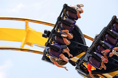 Low angle view of people enjoying roller coaster ride