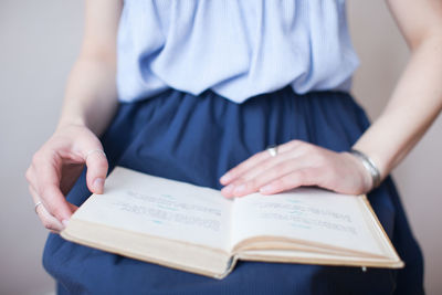 Midsection of woman with book