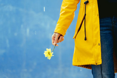 Midsection of man holding yellow flower