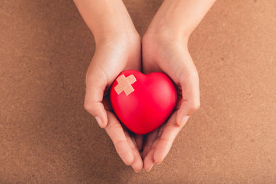 High angle view of woman holding heart shape on hand