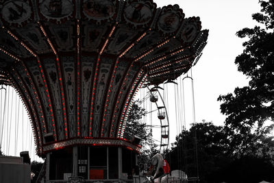 Low angle view of ferris wheel against buildings in city