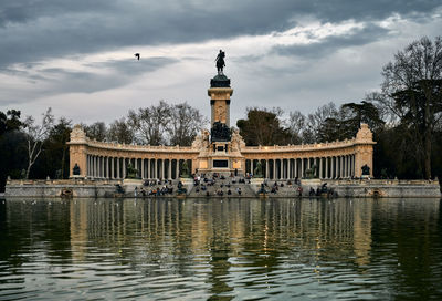 View of statue in lake against cloudy sky