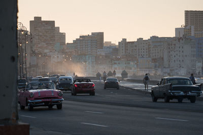 Cars on city street against sky