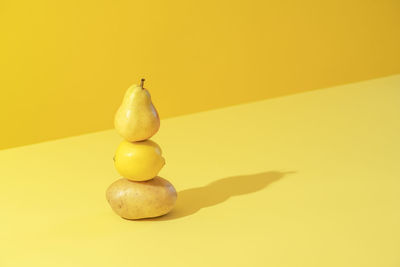 Close-up of apple on table against yellow background