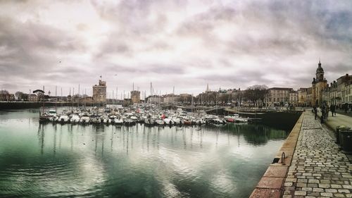 Boats moored in river against buildings in city