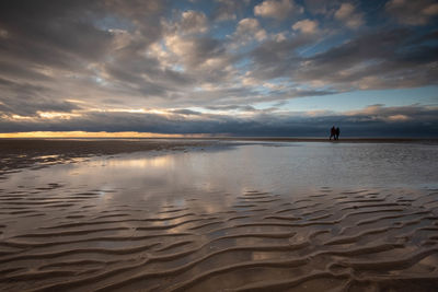 Scenic view of beach against sky during sunset