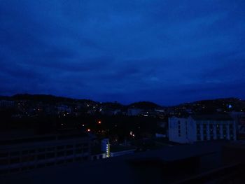 Illuminated cityscape against sky at night