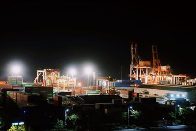 Illuminated buildings against sky at night