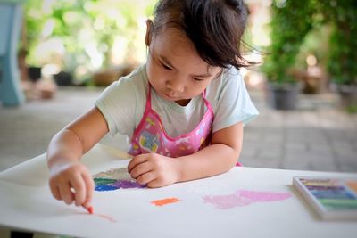 Cute girl coloring on table