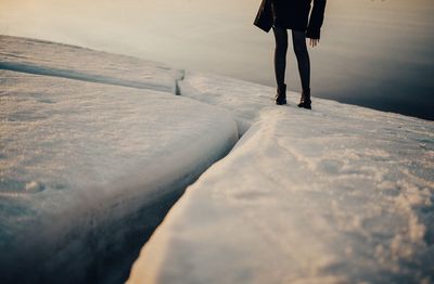 Low section of women walking on snow covered landscape