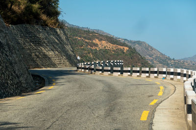 Road by bridge against sky