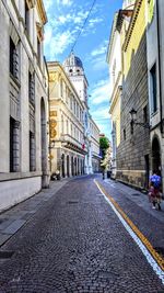 Street amidst buildings in town against sky