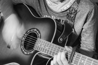 Midsection of man playing guitar