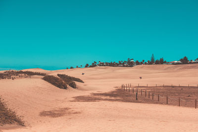 Scenic view of desert against clear blue sky