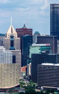 Buildings in city against cloudy sky