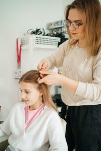 Mom does her daughter hair for a teenager