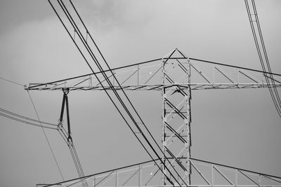 Low angle view of electricity pylon against sky