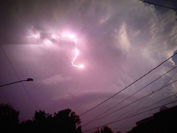 Low angle view of illuminated street light against cloudy sky