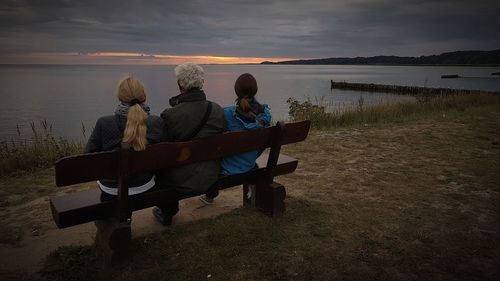 People enjoying at beach during sunset