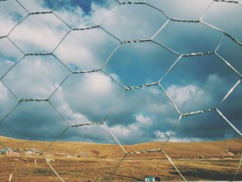 Scenic view of field seen through chainlink fence