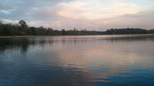 Scenic view of lake against sky at sunset