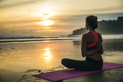 Full length of young woman at beach during sunset