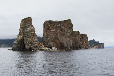 Rock formations by sea against sky